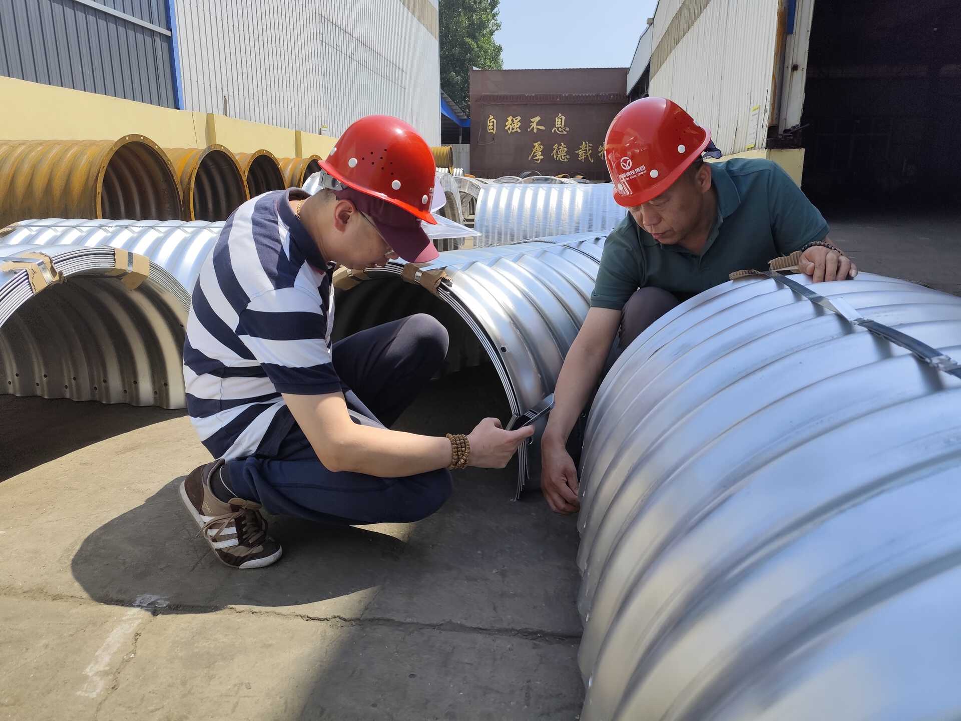 Company executives and client representatives jointly inspect the corrugated culvert pipes